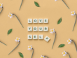 Scrabble letters die de tekst: 'love yourself' vormen op een lichter achtergrond met bloemen